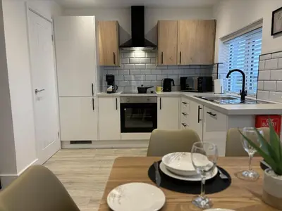 a kitchen with a table with plates and wine glasses at 23 Coastal Comfort in Millom