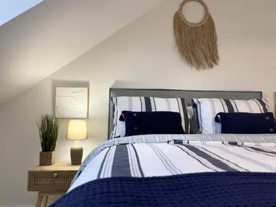 a bedroom with a bed and a mirror on the wall at 23 Coastal Comfort in Millom