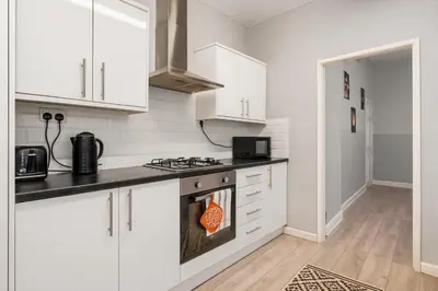 a kitchen with white cabinets and a stove top oven at 4-Bed Contractor House Sleeps 7 Free Parking L20 Liverpool - Hosted by By Hinkley Homes Short Lets & Serviced Accommodation in Liverpool