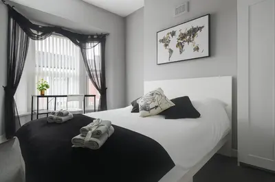a bedroom with a white bed with shoes on it at 4-Bed Contractor House Sleeps 7 Free Parking L20 Liverpool - Hosted by By Hinkley Homes Short Lets & Serviced Accommodation in Liverpool