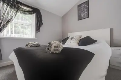 a bedroom with a black and white bed with a window at 4-Bed Contractor House Sleeps 7 Free Parking L20 Liverpool - Hosted by By Hinkley Homes Short Lets & Serviced Accommodation in Liverpool