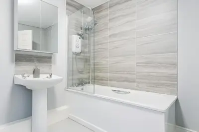 a white bathroom with a shower and a sink at 4-Bed Contractor House Sleeps 7 Free Parking L20 Liverpool - Hosted by By Hinkley Homes Short Lets & Serviced Accommodation in Liverpool