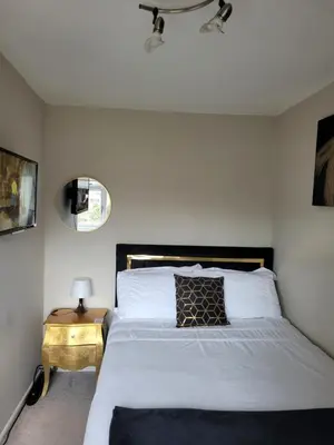 a bedroom with a bed and a side table with a mirror at NB's Cozy Nook, WIGAN in Shevington