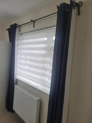 a window with a blue curtain and a radiator at NB's Cozy Nook, WIGAN in Shevington