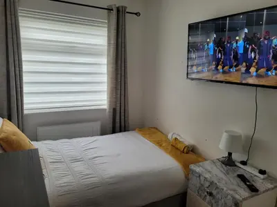 a bedroom with a bed and a tv on the wall at NB's Cozy Nook, WIGAN in Shevington