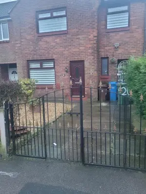 a black fence in front of a brick house at NB's Cozy Nook, WIGAN in Shevington