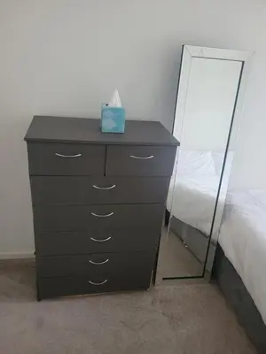 a black dresser with a mirror next to a bed at NB's Cozy Nook, WIGAN in Shevington