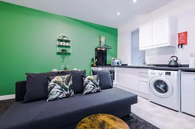 a living room with a couch and a kitchen at Rocky Lane Urban Apartments by Charming Apartments - Flat 3 in Liverpool