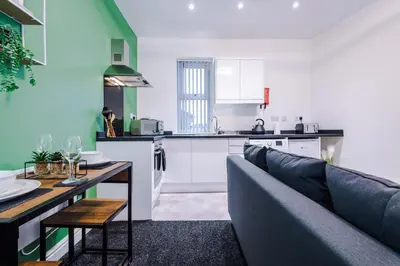 a living room with a couch and a kitchen at Rocky Lane Urban Apartments by Charming Apartments - Flat 3 in Liverpool