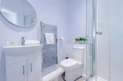 a white bathroom with a toilet and a mirror at Rocky Lane Urban Apartments by Charming Apartments - Flat 3 in Liverpool