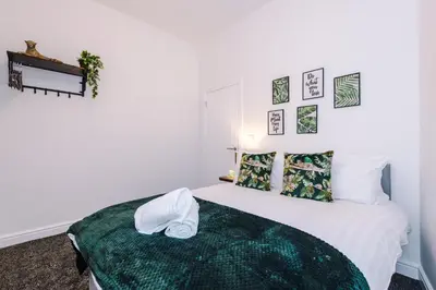 a bedroom with a bed with a green blanket at Rocky Lane Urban Apartments by Charming Apartments - Flat 3 in Liverpool