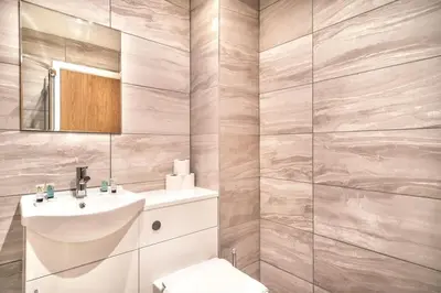 a bathroom with a white sink and a mirror at Contemporary 1 Bed Apartment in Central Preston in Preston