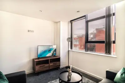 a living room with a flat screen tv next to a window at Contemporary 1 Bed Apartment in Central Preston in Preston
