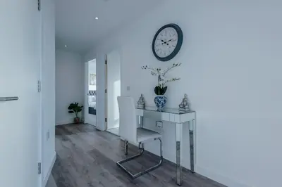 a room with a desk and a clock on the wall at Stunning 2-Bed Premium Apartment - Free WI-FI in Preston