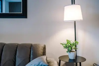 a living room with a couch and a table with a potted plant at Luxury King Size 1-Bed City Apartment - Free WI-FI in Preston