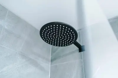 a black shower head hanging on a wall at Luxury King Size 1-Bed City Apartment - Free WI-FI in Preston