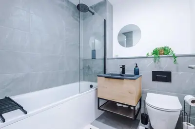 a bathroom with a sink and a toilet and a tub at Luxury King Size 1-Bed City Apartment - Free WI-FI in Preston