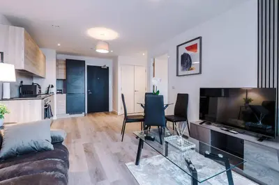 a living room with a couch and a table with chairs at Luxury King Size 1-Bed City Apartment - Free WI-FI in Preston
