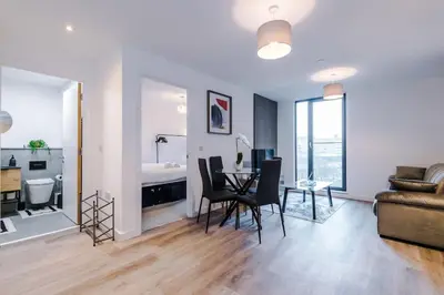 a living room with a table and chairs and a living room at Luxury King Size 1-Bed City Apartment - Free WI-FI in Preston