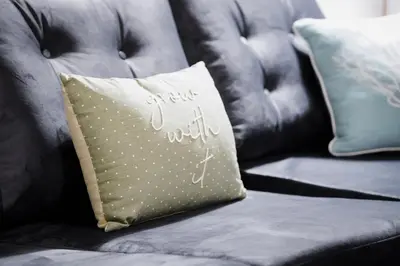 a gray couch with a pillow on it at Stylish 2 bedroom flat - 15 minutes to Liverpool City Centre in Birkenhead