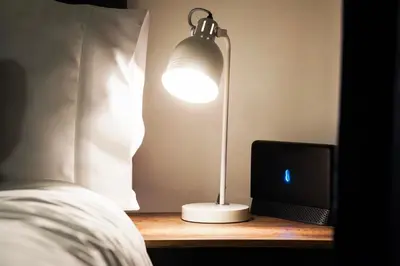 a lamp sitting on a table next to a bed at Stylish 2 bedroom flat - 15 minutes to Liverpool City Centre in Birkenhead