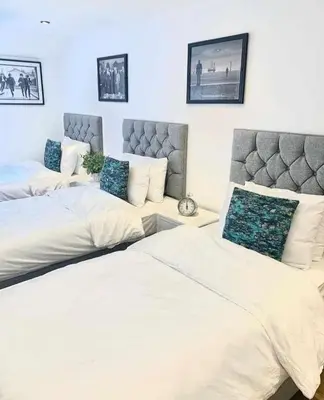 a bedroom with two beds and a couch at Camden Apartments 2 in Liverpool