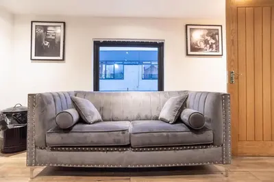 a leather couch with pillows in a living room at Camden Apartments 2 in Liverpool
