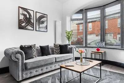 a living room with a couch and a table at 2 Bed Flat - Sleeps 8 - Pets - Parking - Wifi in Blackpool