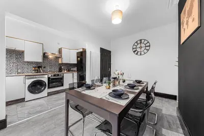 a dining room with a table and chairs in a kitchen at 2 Bed Flat - Sleeps 8 - Pets - Parking - Wifi in Blackpool