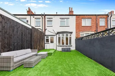 a backyard with green grass and a couch at 2 Bed Flat - Sleeps 8 - Pets - Parking - Wifi in Blackpool