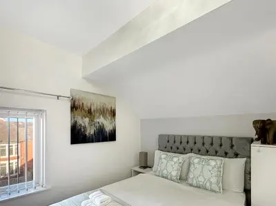 a white bedroom with a bed and a window at Granada Apartments Holmfield Rd in Blackpool