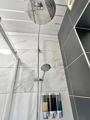 a shower in a bathroom with a shower head at Granada Apartments Holmfield Rd in Blackpool