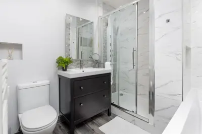 a white bathroom with a shower and a toilet at Flatzy - 3 Bedroom Apartment in Heart of City Centre in Liverpool