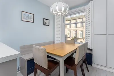 a dining room with a wooden table and chairs at Flatzy - 3 Bedroom Apartment in Heart of City Centre in Liverpool