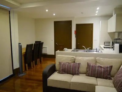 a living room with a couch and a kitchen at Liver View Apartments in Liverpool