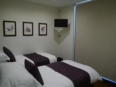 a room with two beds and a tv on the wall at Liver View Apartments in Liverpool