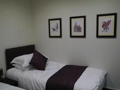 a bedroom with two beds and pictures on the wall at Liver View Apartments in Liverpool