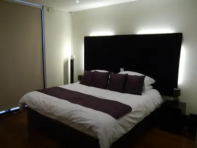 a bedroom with a large bed with a black headboard at Liver View Apartments in Liverpool