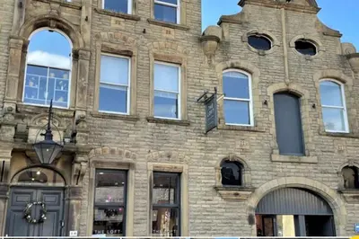 an old brick building with many windows on it at CLITHEROE TOWN CENTRE MODERN 2 BED APARTMENT in Clitheroe