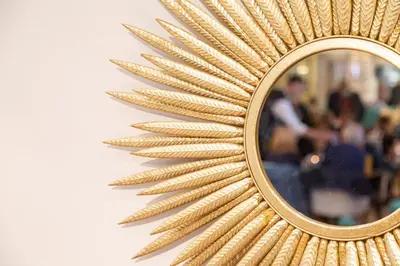 a mirror with a gold leaf design on a wall at Rufford Arms Hotel in Rufford
