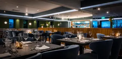 a restaurant with tables and chairs and a bar at Foxfields Country Hotel in Langho