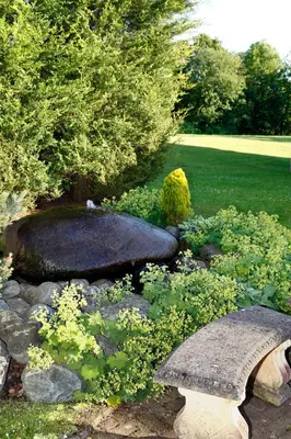 a garden with a stone bench and some plants at Foxfields Country Hotel in Langho