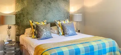 a bedroom with a bed with blue and yellow pillows at Foxfields Country Hotel in Langho