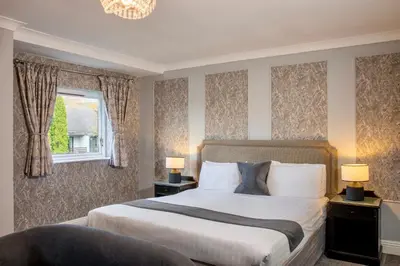 a bedroom with a large bed and a window at Foxfields Country Hotel in Langho