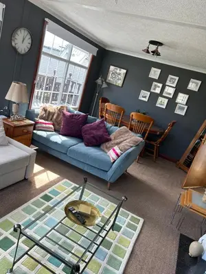 a living room with a blue couch and a clock at Sunshine Lodge Haven Lakeland in Flookburgh