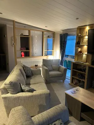 a living room with two couches and a tv at Blissful Lodge Haven Lakeland in Flookburgh