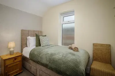 a bedroom with a bed and a window at Arnside - Spacious 10-Bedroom Seaside Cottage in Blackpool