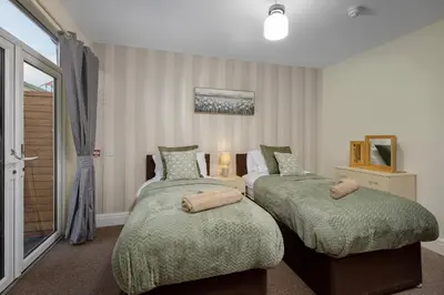 a bedroom with two beds and a window at Arnside - Spacious 10-Bedroom Seaside Cottage in Blackpool