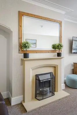 a fireplace with two potted plants on top of it at Arnside - Spacious 10-Bedroom Seaside Cottage in Blackpool