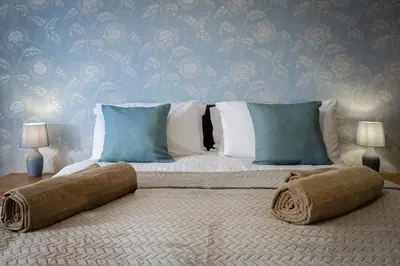 a bedroom with a bed with pillows on it at Arnside - Spacious 10-Bedroom Seaside Cottage in Blackpool